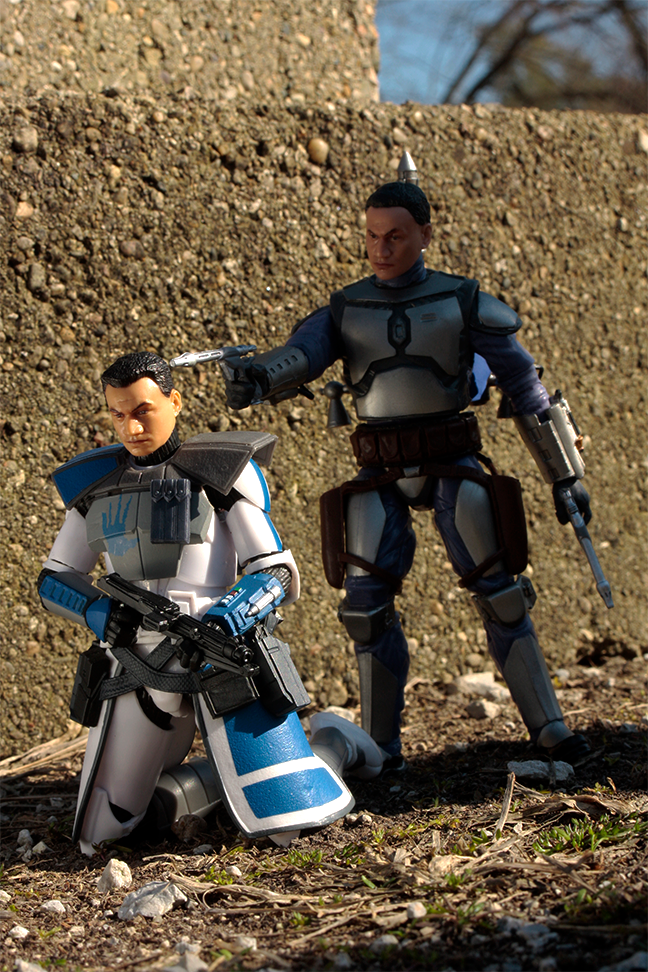  Photo showing figures of Jango Fett from Star Wars pointing blaster to the head of a clone trooper from Star Wars.